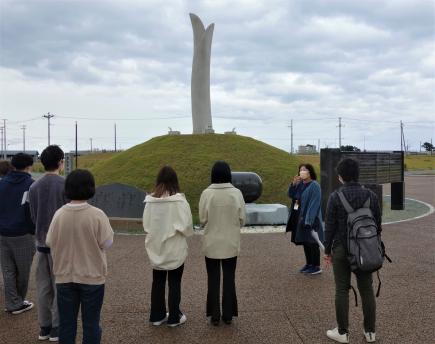 閖上の慰霊碑を、語り部の丹野さんと訪ねた受講生たち