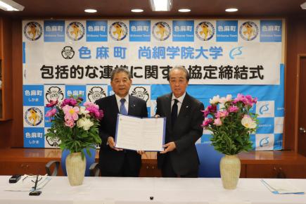 協定書に署名する早坂町長（左）と髙木学長（右）